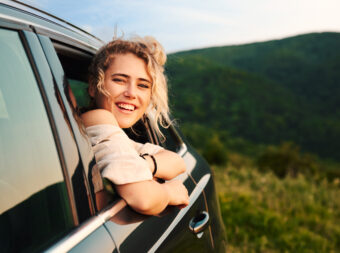 happy young blonde woman leaning out of the car wi 2023 06 01 17 43 24 utc